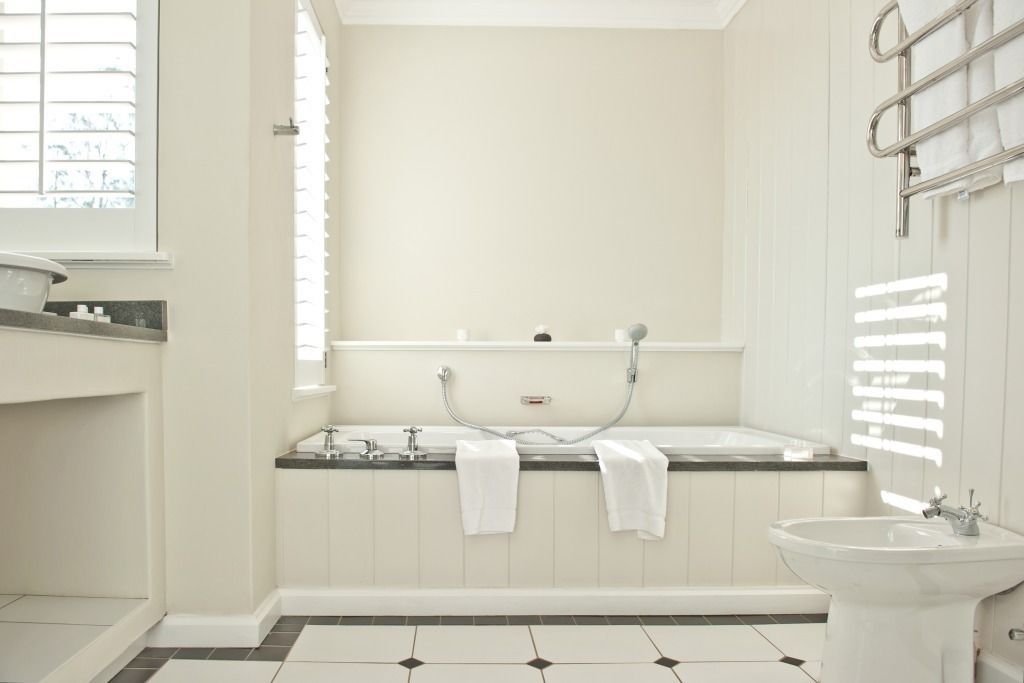 A modern bathroom with a bathtub, a sink, and a window.