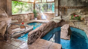 A pool area with a view of trees, a potted plant, and a stone wall. - BLUESEA Costa Jardín Spa (Puerto de la Cruz)