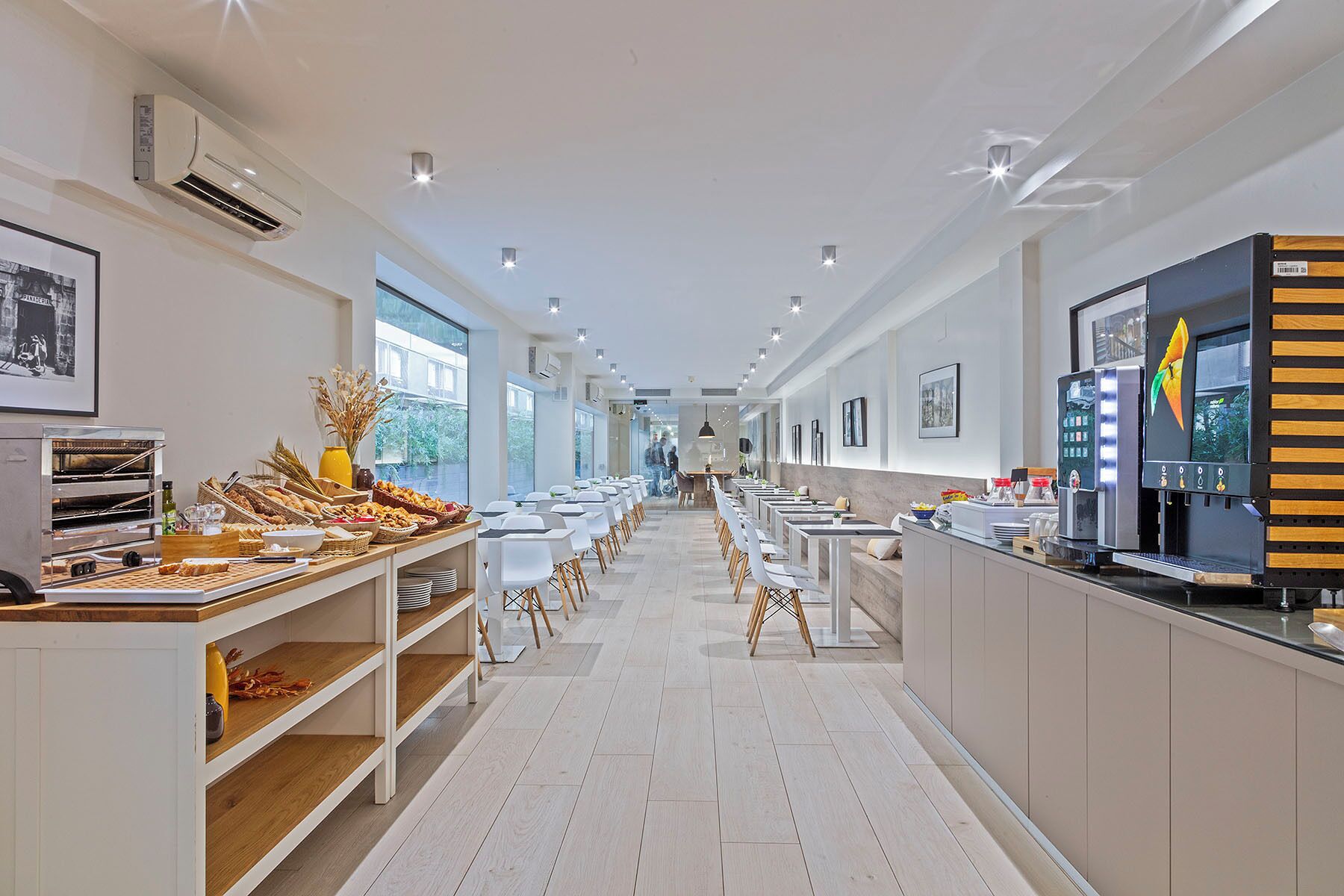 Un hall d’hôtel moderne avec un long comptoir d’accueil, un espace salon et un buffet.
