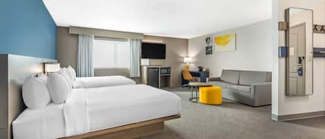 Een hotelkamer met een groot bed, een bureau, een bank en een televisie.