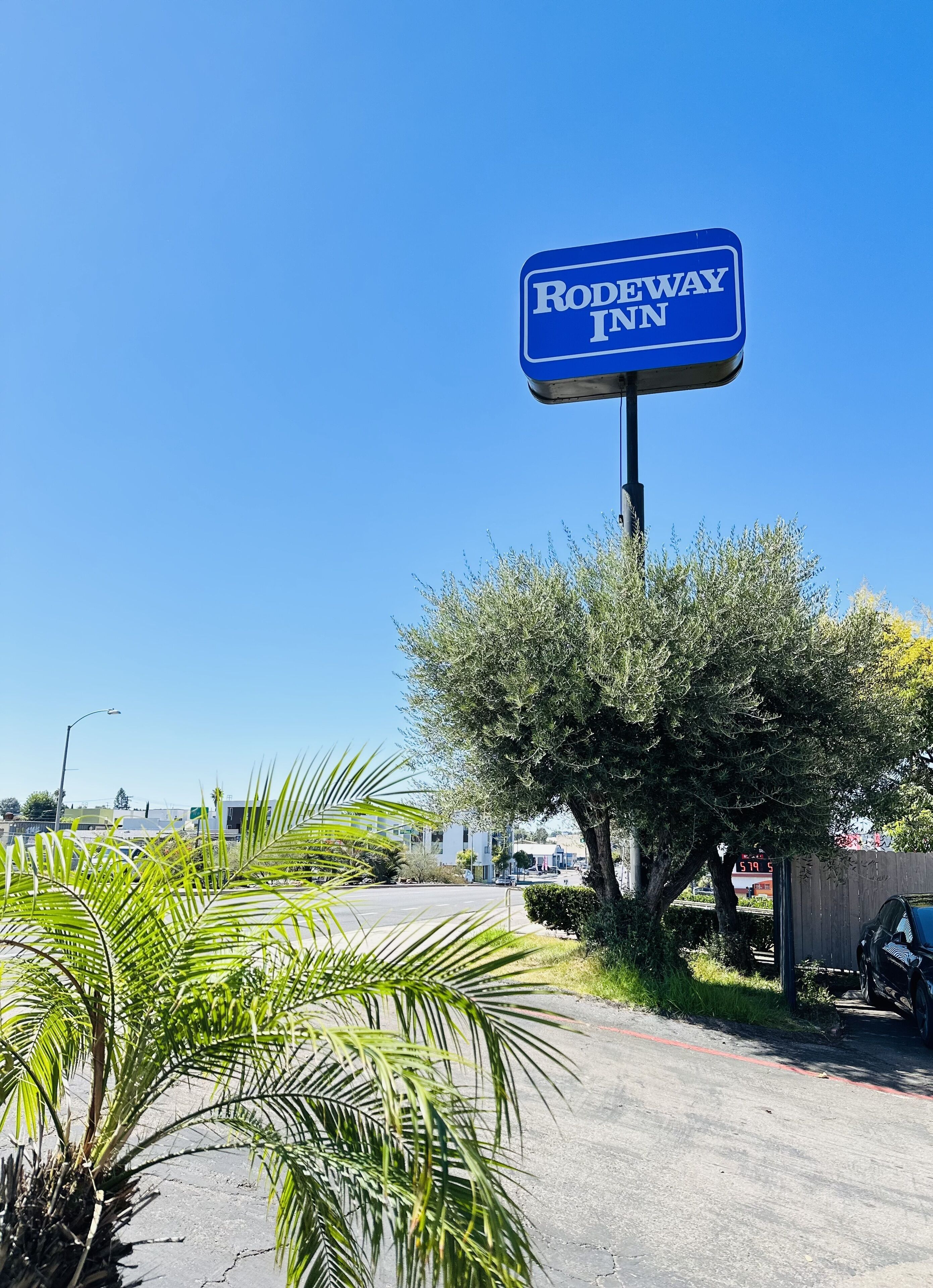 Un panneau bleu avec l’inscription « RODEWAY INN ».