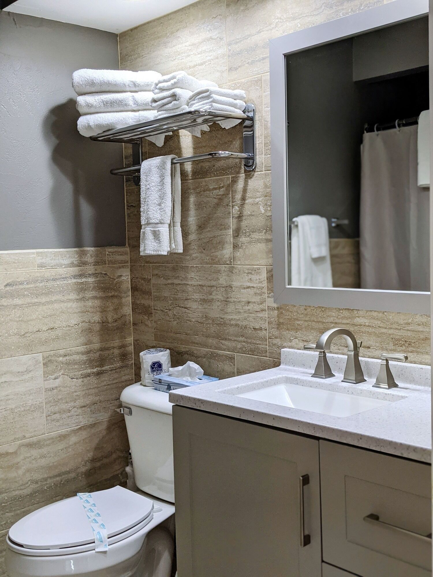 Une salle de bain équipée de toilettes, d’un lavabo et d’un porte-serviettes.