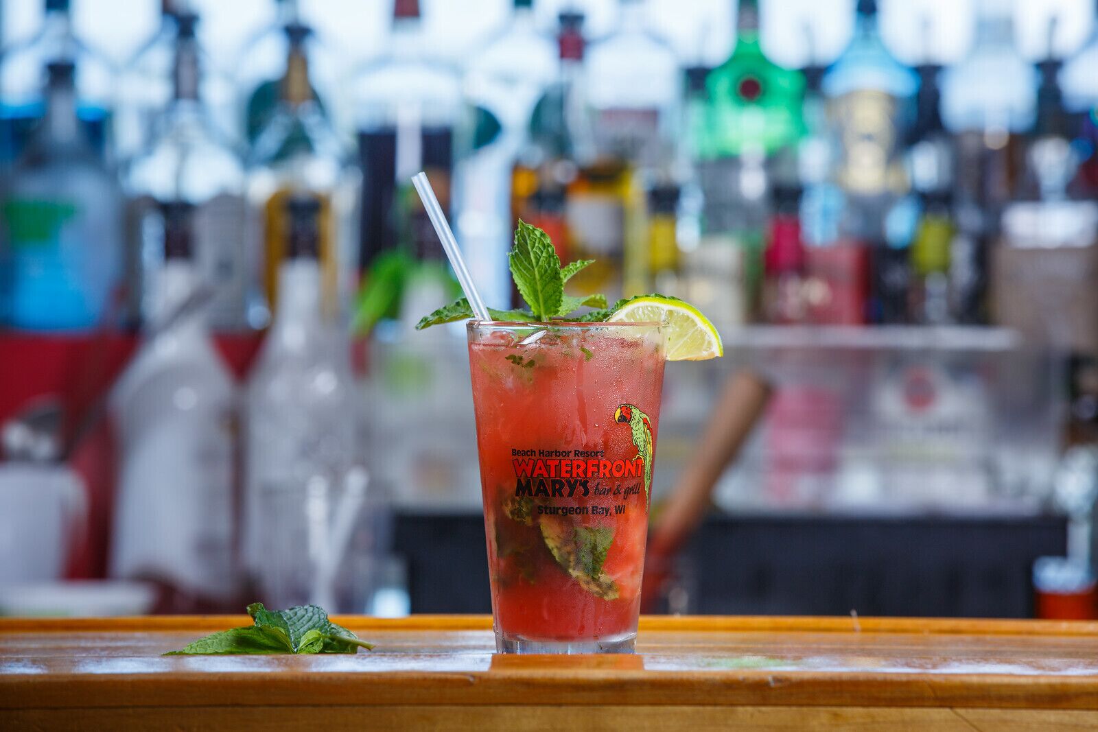 A tall glass with a straw, garnished with a lime wedge and mint leaves, labeled "WATERFRONT" and "MARRYS bar & grill."