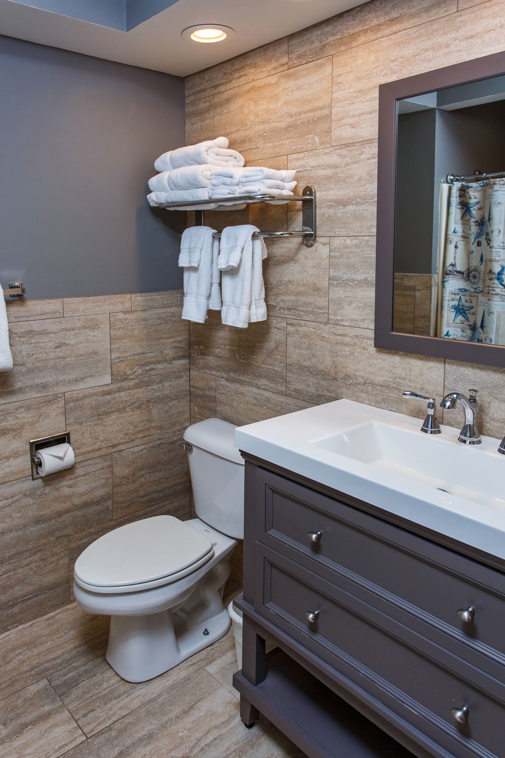 Un baño moderno con inodoro, lavamanos y perchero para toallas.