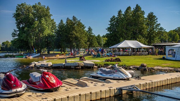 A lakeside dock with jet skis and a white tent. - Beach Harbor Resort (Sturgeon Bay)