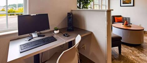 Un bureau moderne, de type « open space », équipé d’un écran Dell, d’un clavier et d’une petite plante en pot.