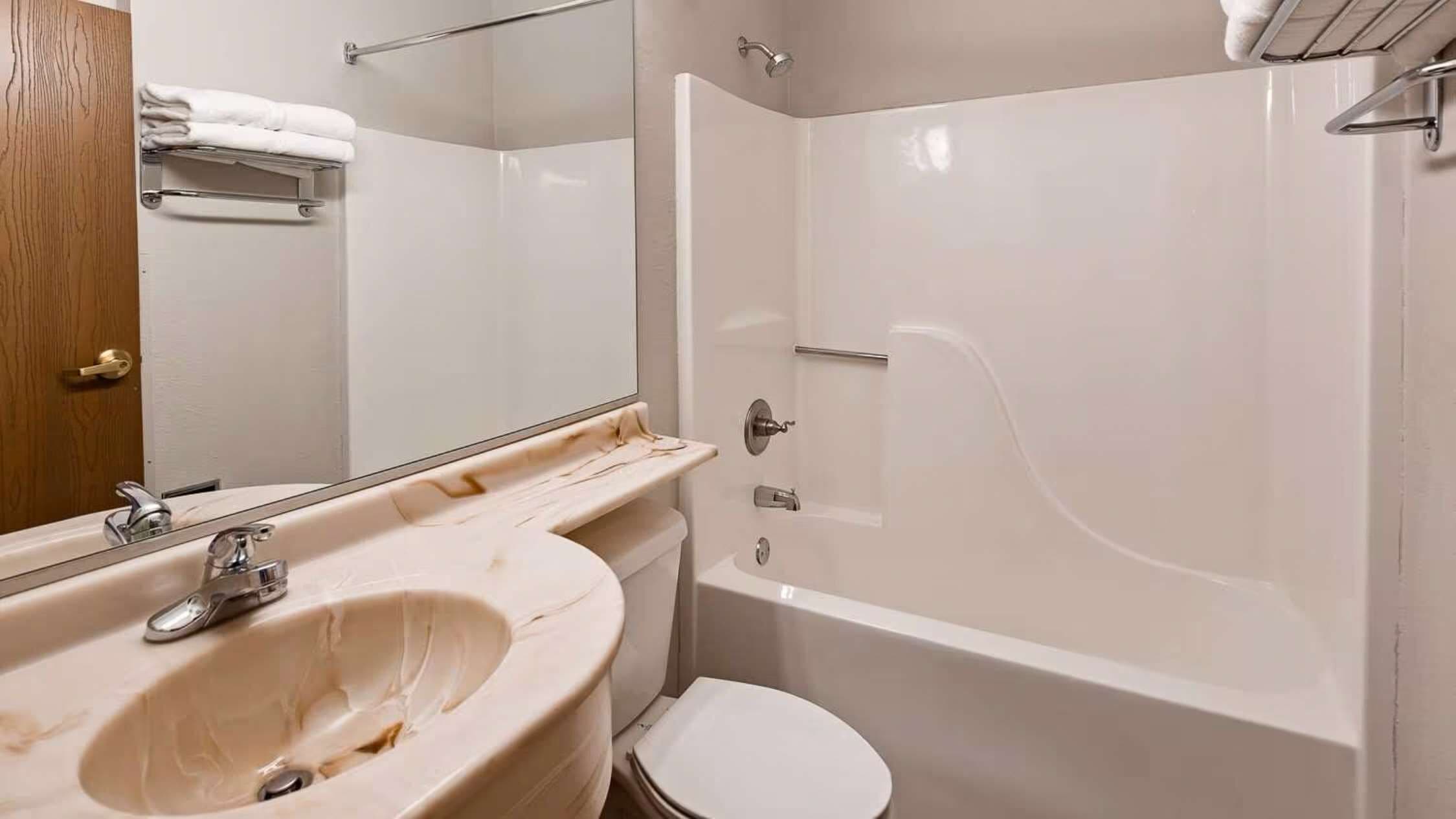 Un bagno con lavandino, water e doccia.