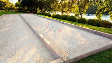 A shuffleboard table with colorful pucks in a park setting.