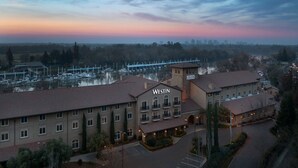Een hotel met een opvallend “WESTIN” bord, een jachthaven met boten, en een zonsondergang lucht.