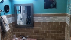 A bathroom with a sink, mirror, and toilet. - Travel Inn And Suites (Victorville)