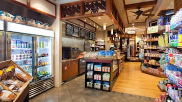 A grocery store interior with refrigerated sections, shelves stocked with various products, and a bakery display.