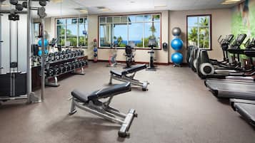 Une salle de sport équipée de tapis de course, d’appareils de musculation et d’haltères.