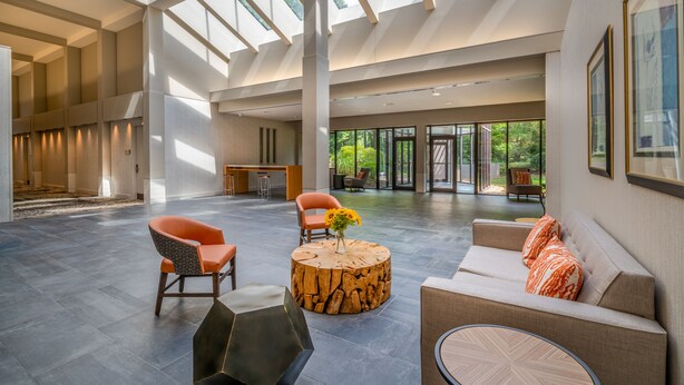 A spacious lobby with high ceilings, a central wooden coffee table, and seating areas. - Crowne Plaza Atlanta SW - Peachtree City by IHG (Peachtree City)