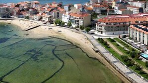 A coastal town with buildings along the waterfront, a sandy beach, and a clear view of the sea. - Hotel Carril (Vilagarcia de Arousa)