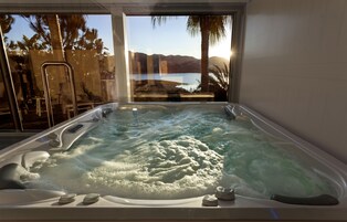 Un jacuzzi con vistas a un lago y montañas.