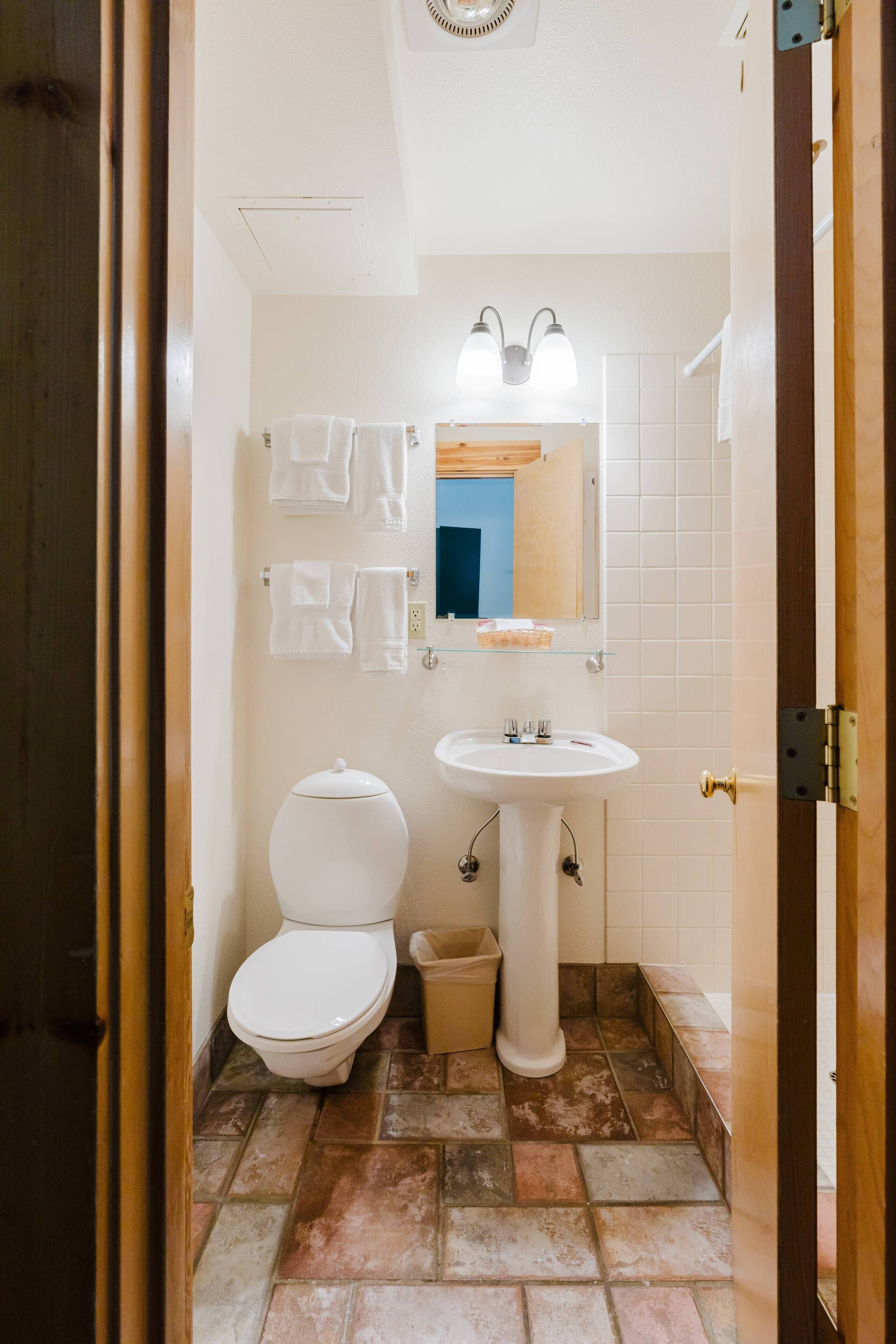 Ein Badezimmer mit Toilette, Waschbecken und zwei Handtuchhaltern an der Wand.