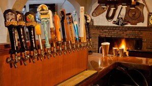 A bar area with multiple beer taps and a fireplace. - Crystal Mountain Hotels (Enumclaw)