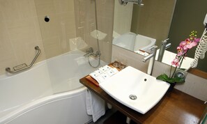 Un baño con bañera, lavamanos y ducha.