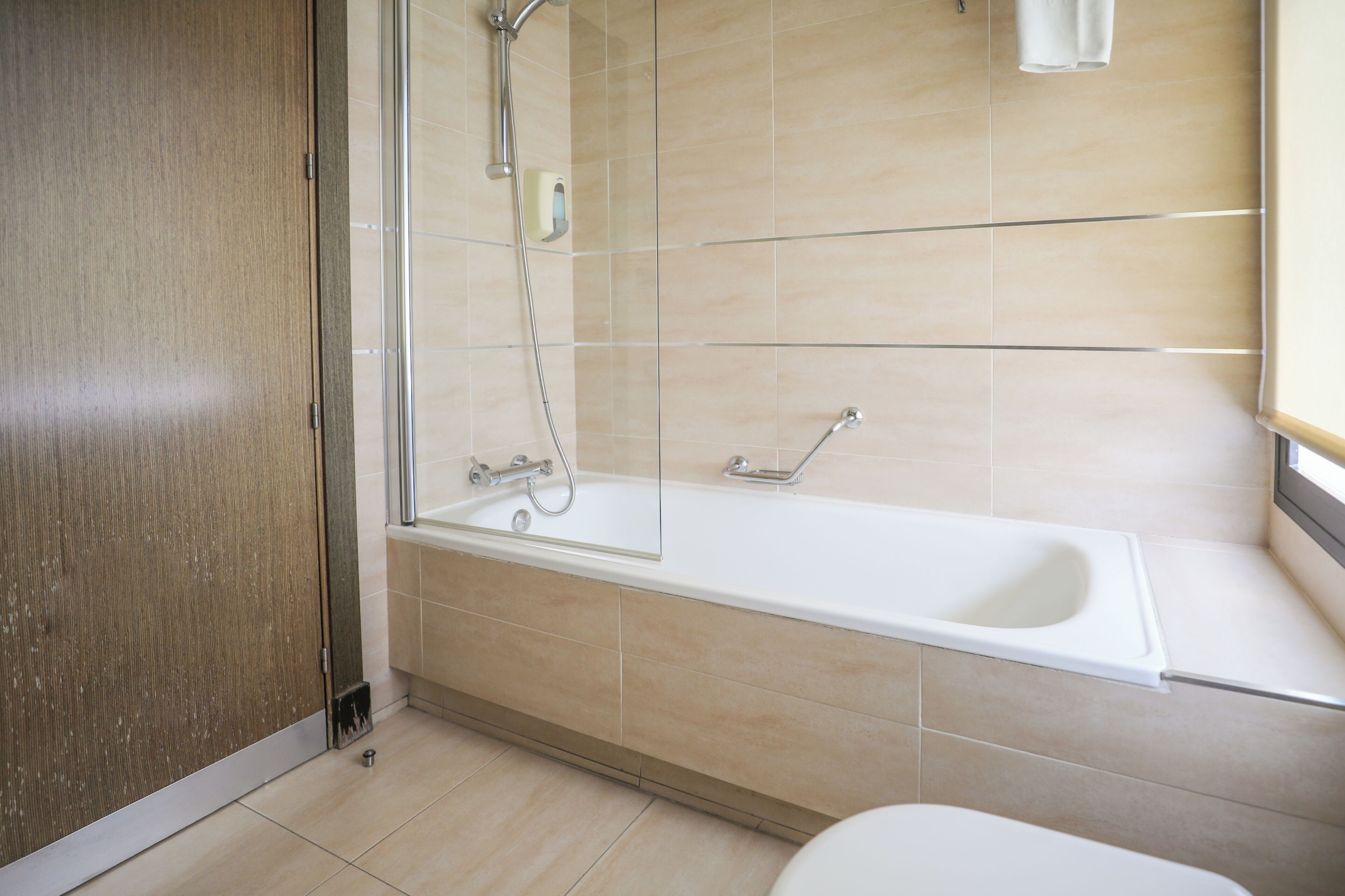 Un baño con bañera, ducha e inodoro.