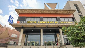 Un hôtel avec une enseigne indiquant : « HÔTEL CONQUISTA DE GRANADA ».