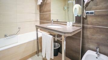 Un baño moderno con lavamanos doble, bañera e inodoro con ducha.