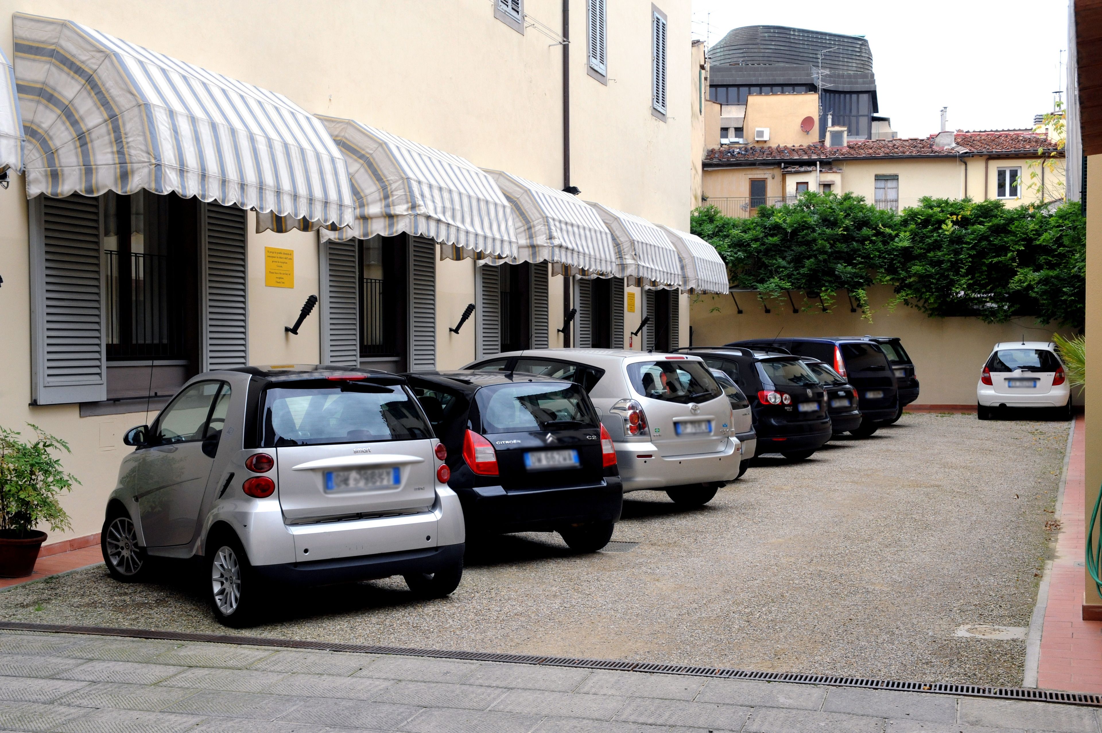 A row of parked cars in a narrow street with buildings on either side.