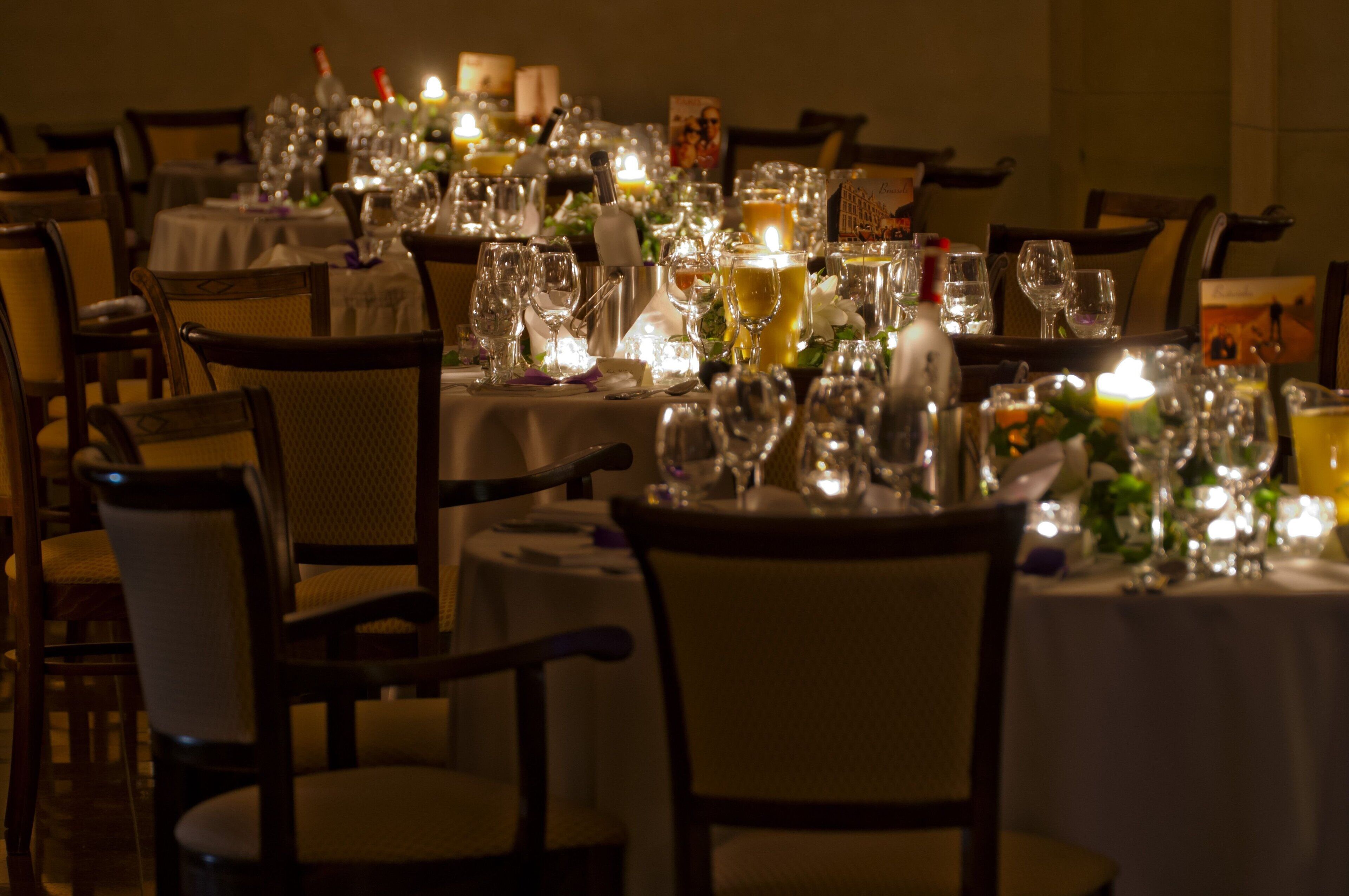 Ein Restaurantambiente mit runden Tischen, Stühlen und verschiedenen Besteck.