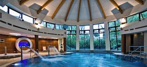 Una piscina techada, sillones reclinables de piscina