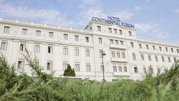 A large, multi-story hotel with a prominent sign reading "HOTEL CONTINENTAL FORUM".