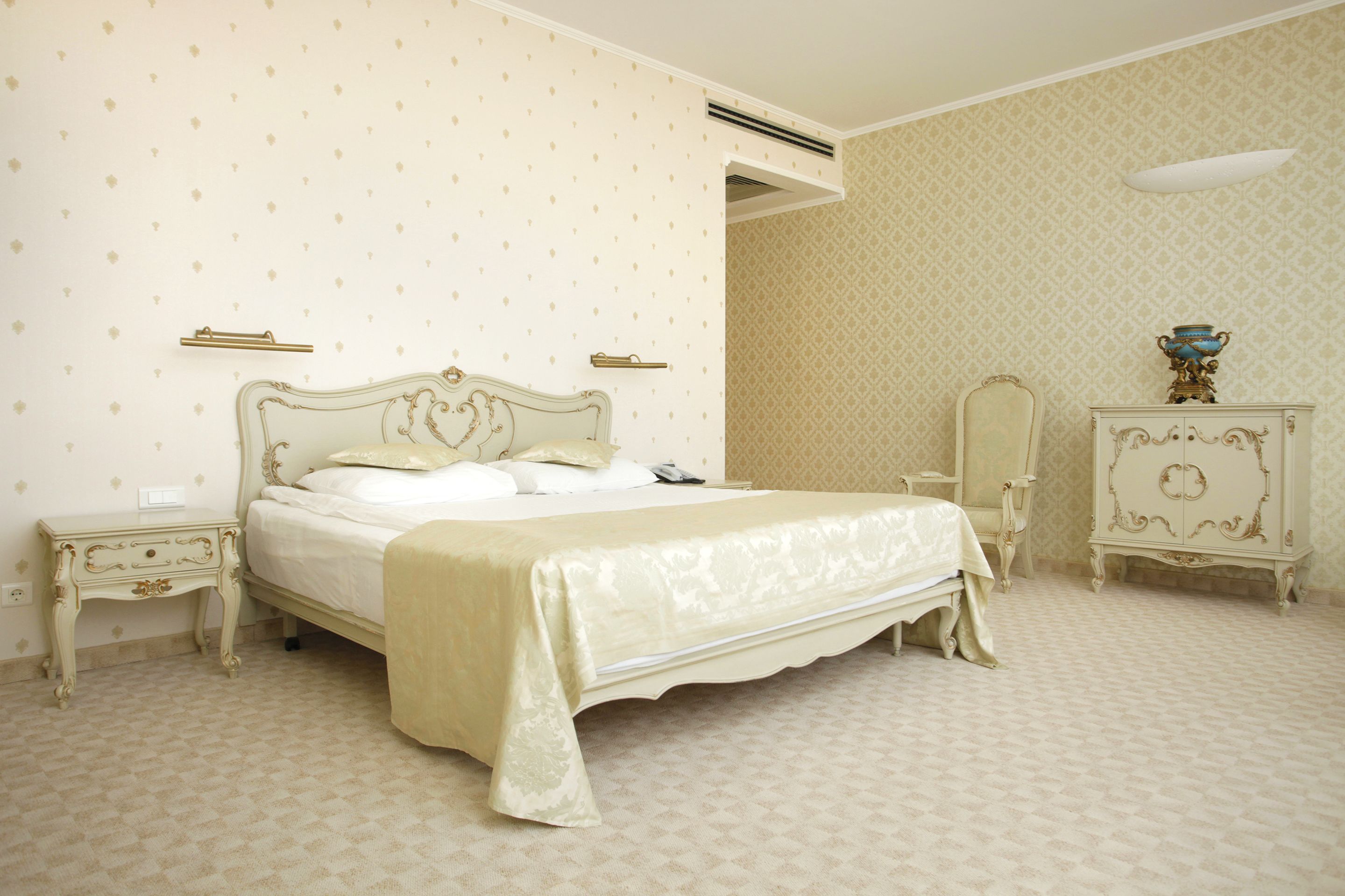 A classic bedroom with a four-poster bed, a nightstand, a dresser, and a mirror.