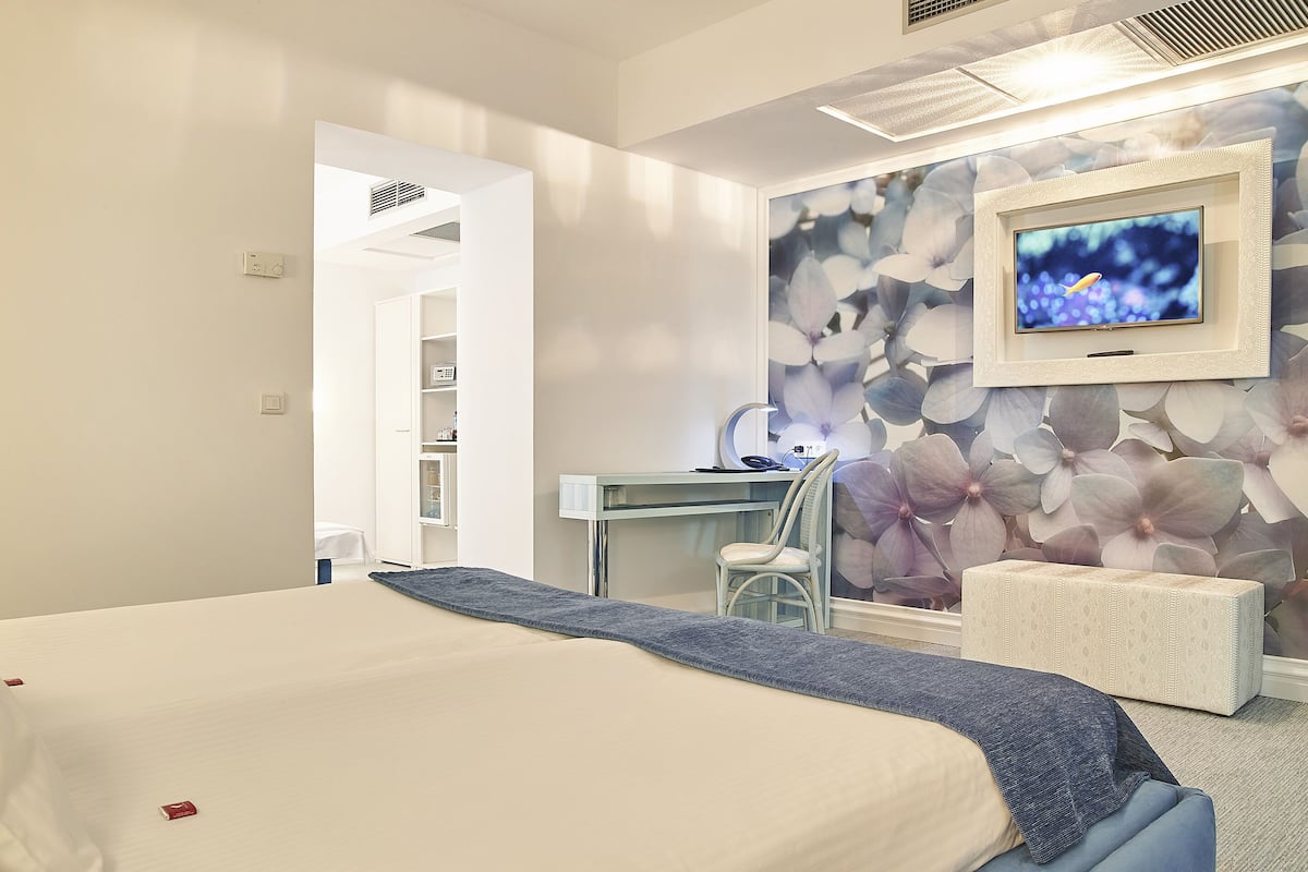 A modern bedroom with a bed, a desk, and a chair.