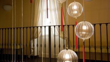 A staircase with a black balustrade and clear glass pendant lights with red tassels.