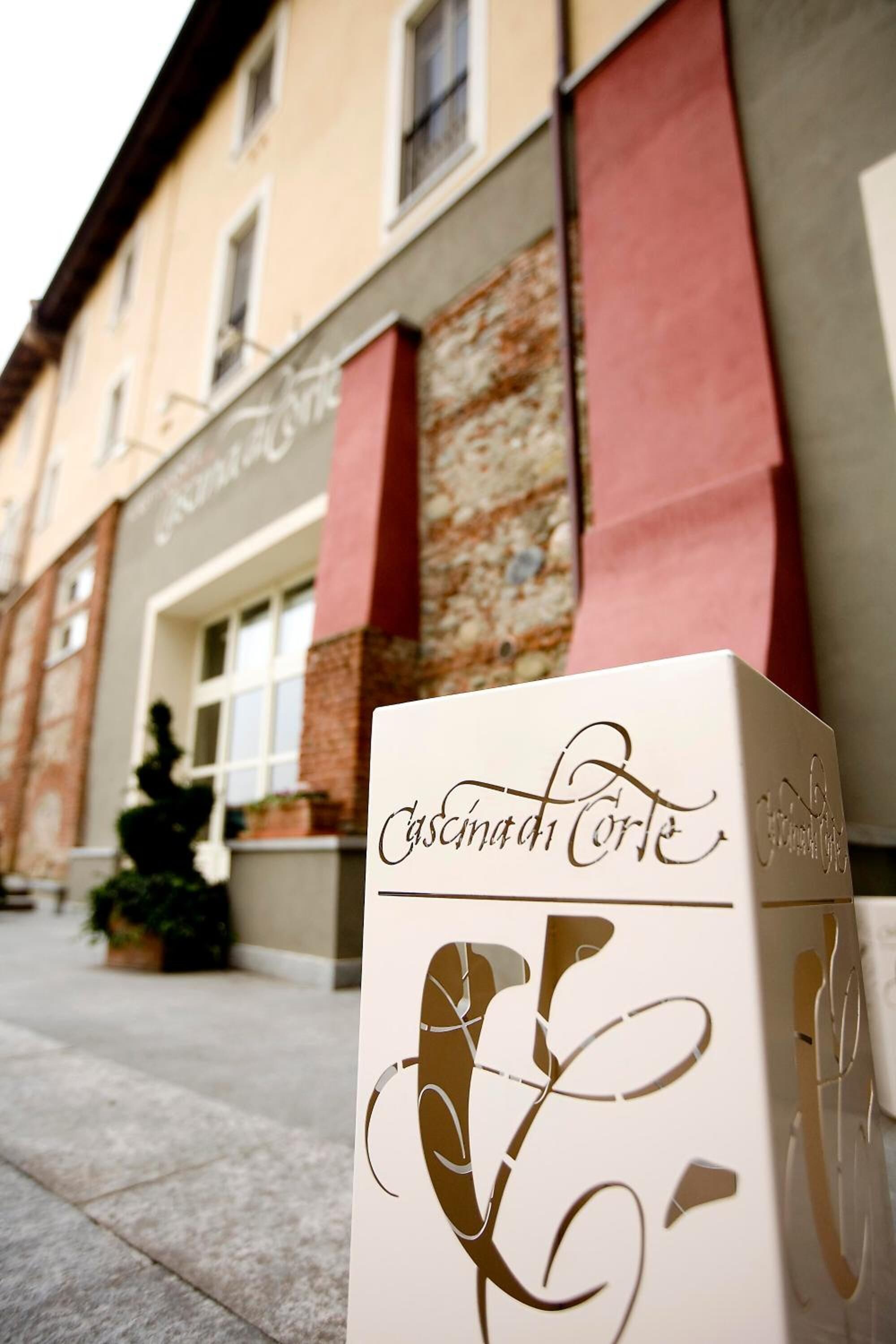 A building facade with a sign that reads "Cascina di Corte."