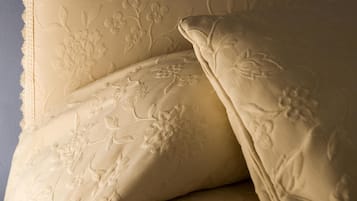 Una cama con ropa de cama de estampado floral y un cabecero.
