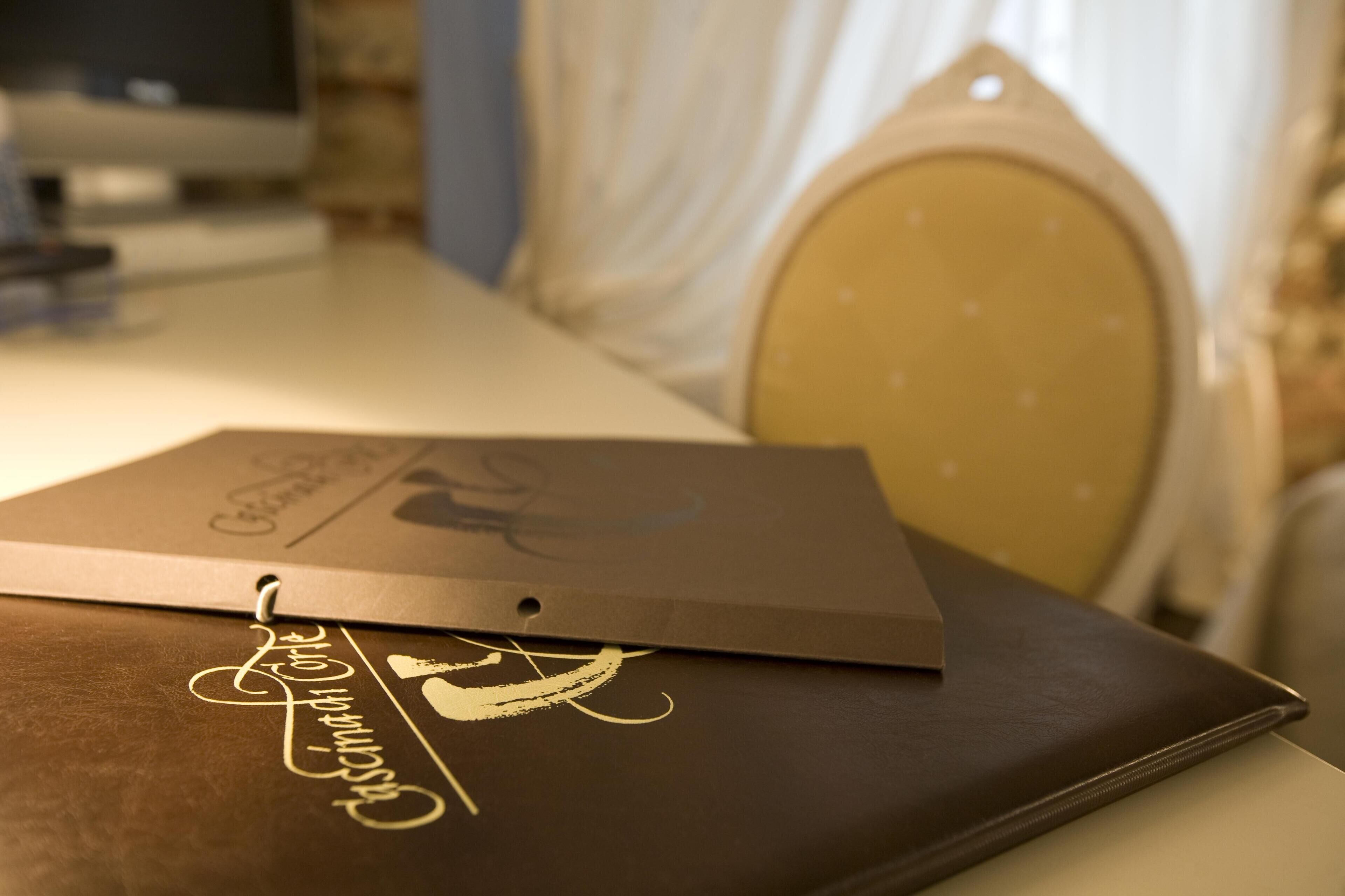 Uma pasta marrom com texto dourado sobre uma mesa.