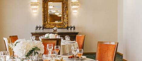 A dining table set with plates of food, wine glasses, and a vase of flowers.