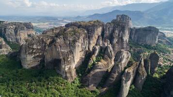 A landscape with tall, rugged rock formations surrounded by dense greenery.