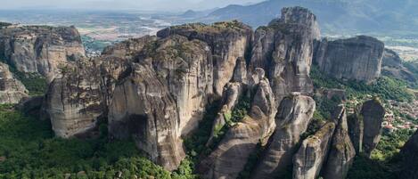 A landscape with tall, rugged rock formations surrounded by dense greenery.
