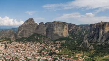 A town with red-roofed buildings nestled between rocky cliffs.