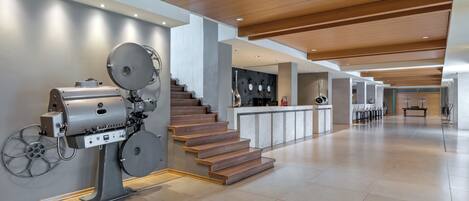 A spacious interior with a modern kitchen, a staircase, and a bar area.