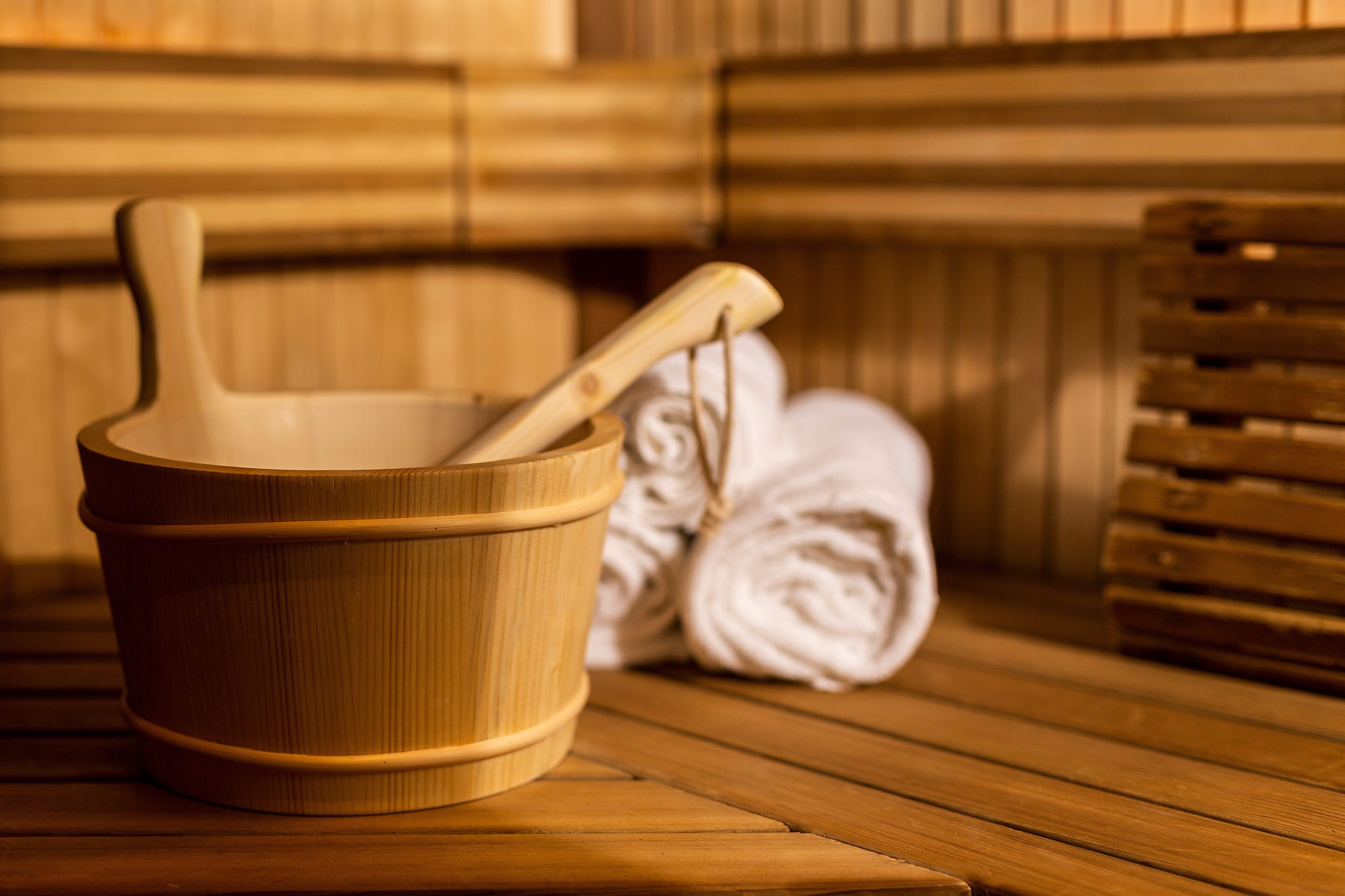 A wooden bathtub with a wooden bucket and a wooden ladle.