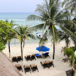 Aan een privéstrand, wit zand, parasols, strandlakens