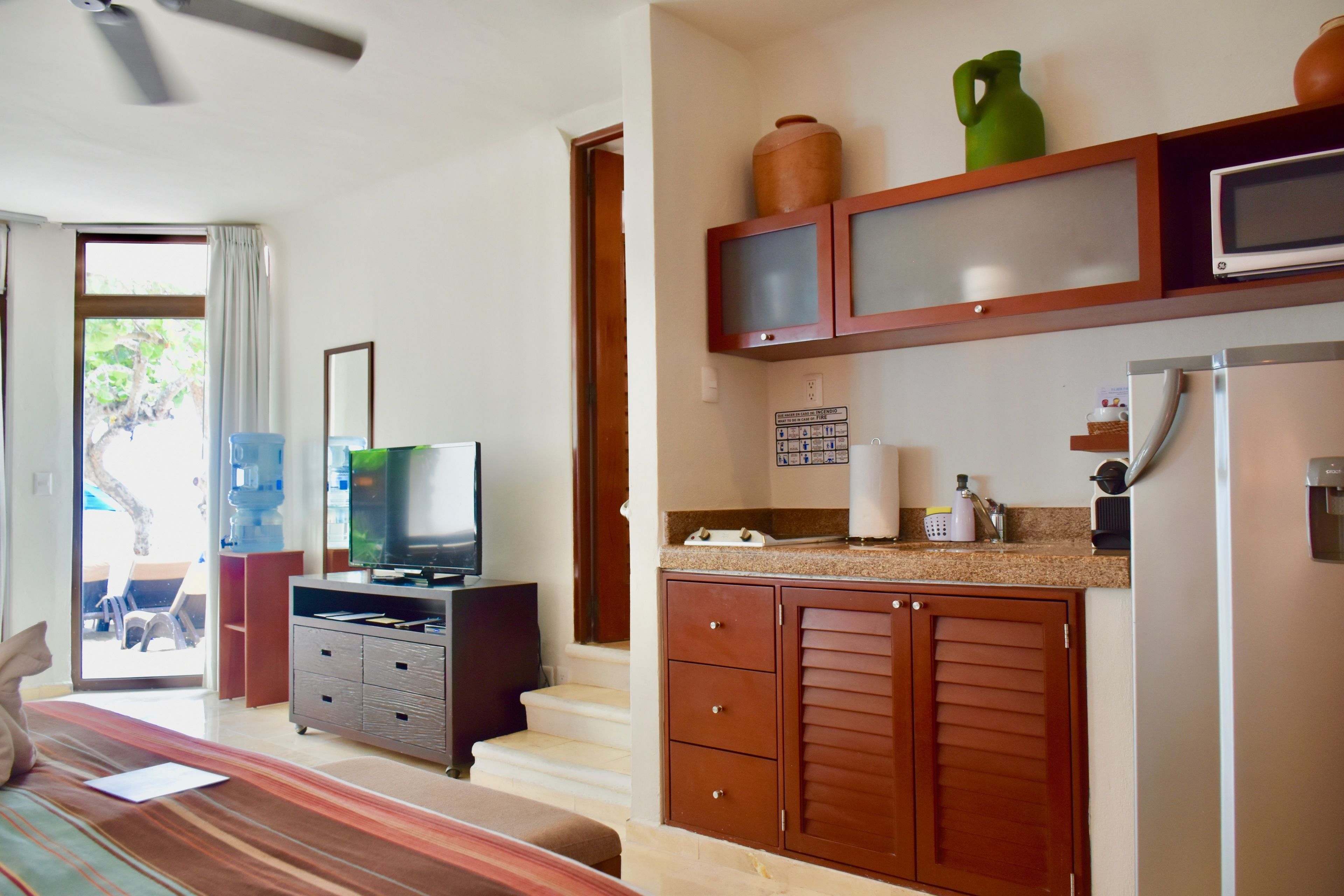 A compact living space with a kitchenette, a television, and a dining area.