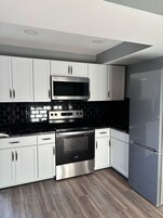 Habitación doble, 2 camas de matrimonio | Zona de estar | Televisión de pantalla plana de 27 pulgadas con canales por cable