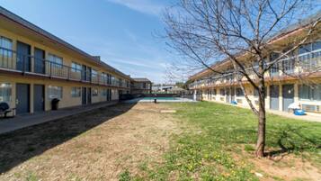 Un patio con piscina, rodeado de edificios con balcones y ventanas.