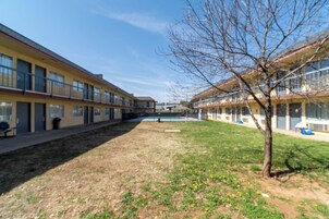 Un patio con piscina, rodeado de edificios con balcones y ventanas.