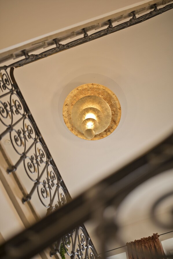 Un plafond orné d’un luminaire circulaire et d’une rambarde en métal.