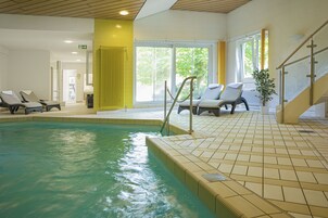 Una piscina techada, sillones reclinables de piscina