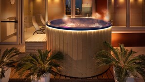 A hot tub with a wooden deck and a glass door leading to a room. - Hotel Ascot & Spa (Rimini)