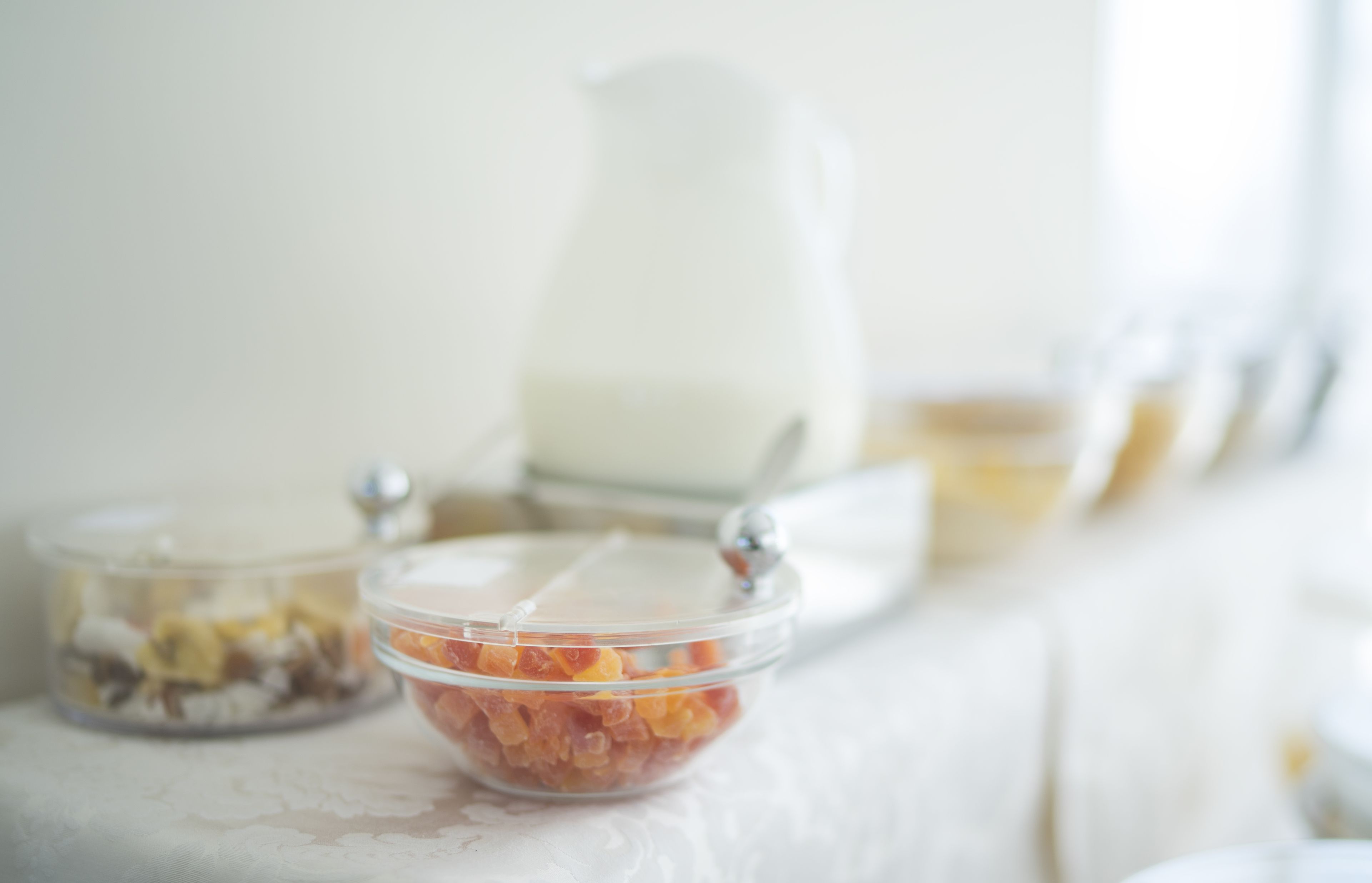 A table with a milk jug and two containers of food.
